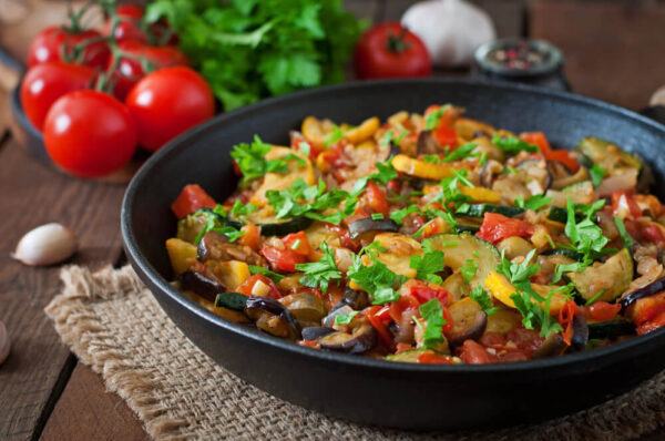Vegetable stir-fry in a black skillet.