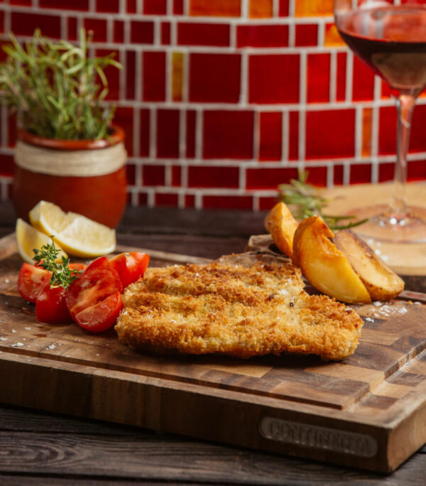 Breaded cutlet with tomatoes and potatoes.