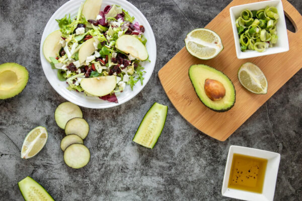 Salad with avocado, lime, and cucumber slices.