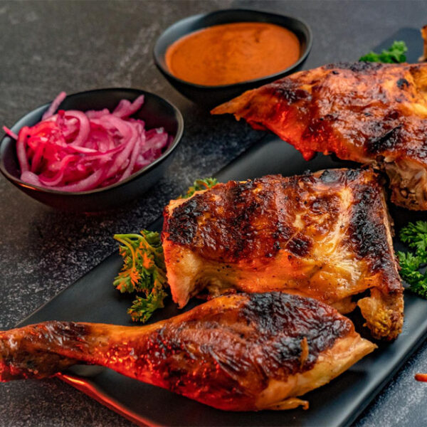 Grilled chicken with sauce and pickled onions.