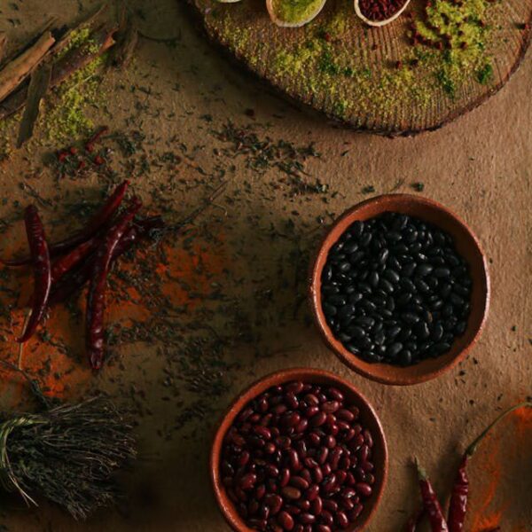 Assorted spices and beans on textured surface.