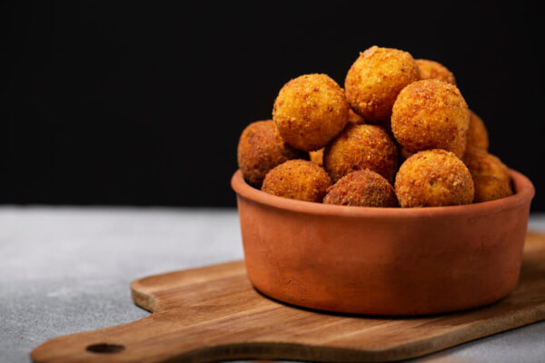 Fried cheese balls in a clay bowl.