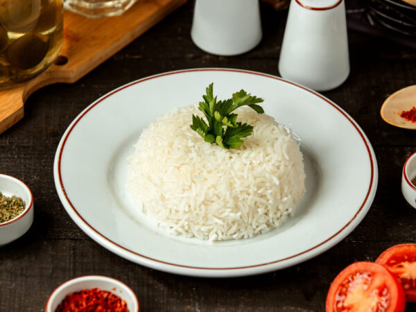 White rice garnished with parsley on plate.