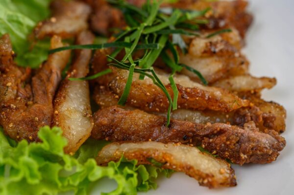 Fried pork strips with greens on lettuce.